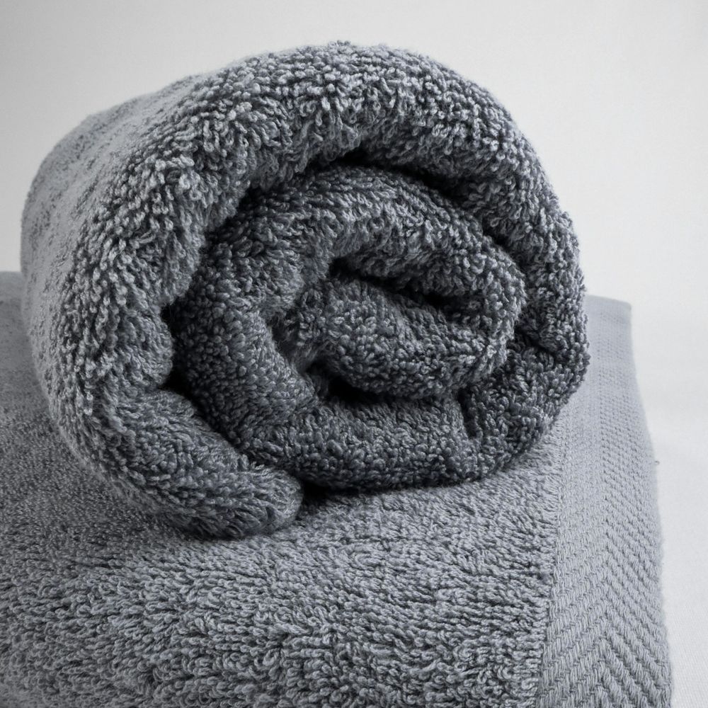 Rolled slate grey terry-cloth towel with a woven border